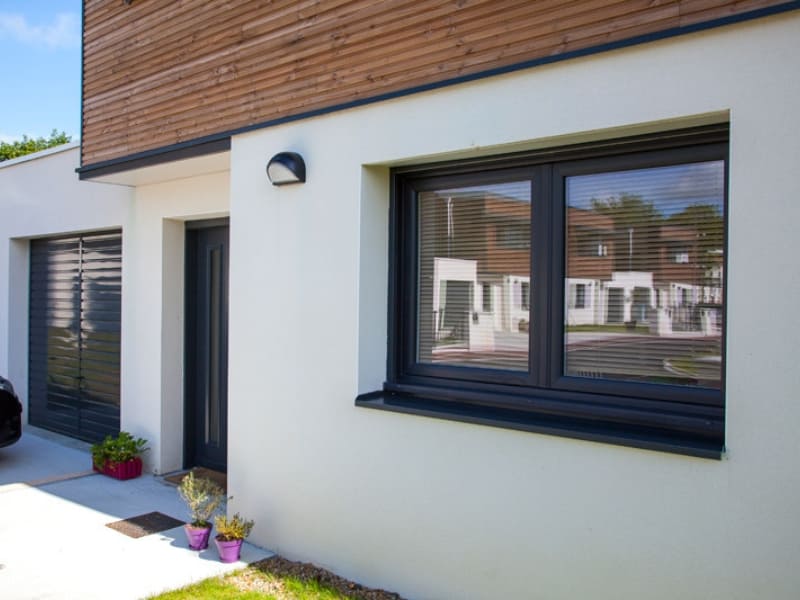 Photo extérieure d'une maison moderne, avec de nouvelles fenêtres en ALU de couleur bleu foncé.