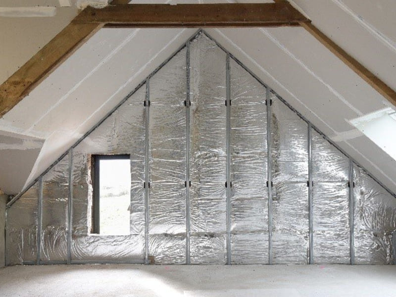 Isolation d'un mur par l'intérieur via l'utilisation de panneaux roulés de la marque Knauf.