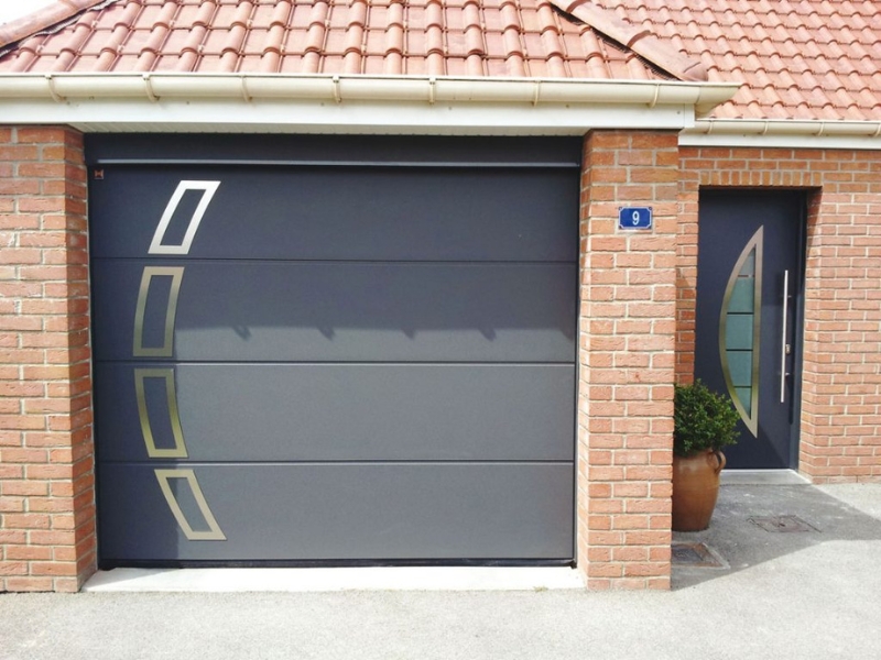Photo d'une porte de garage moderne de couleur noire avec des effets de dorures.